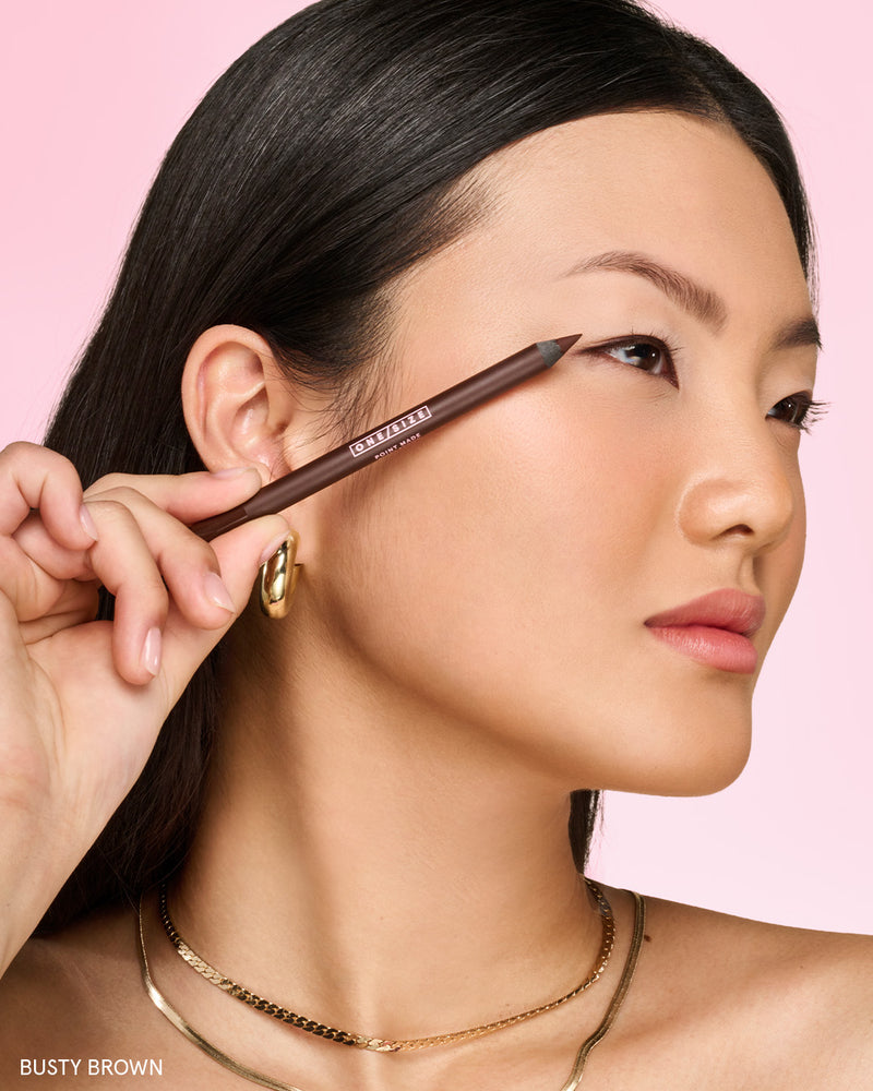Translation missing: en.Model wearing ONE/SIZE Point Made Gel Eyeliner Pencil in Busty Brown, holding the pencil near her face